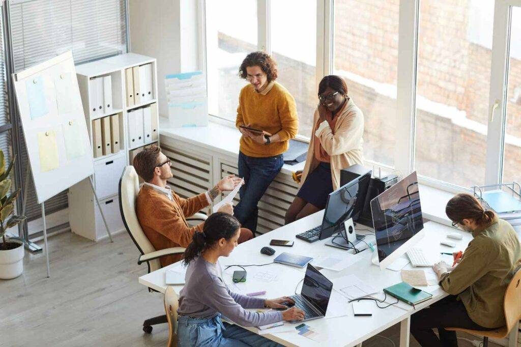 Lehrpersonal der HOGA Schule Dresden arbeitet gemeinsam an einem Projekt im offenen Büro