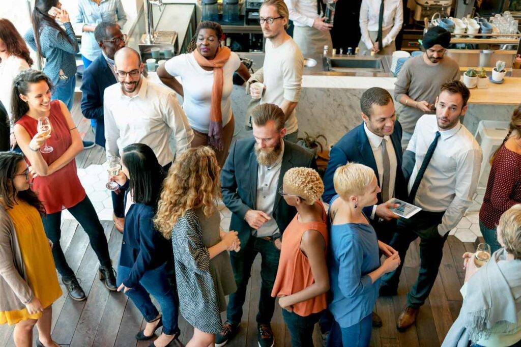 Menschen vernetzen sich bei einem lockeren Get-together an der Bar der HOGA Schulen in Dresden