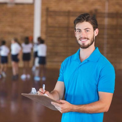Sportlehrer Job Dresden HOGA Schule Männlicher Sportlehrer mit Klemmbrett in der Turnhalle der HOGA Schule Dresden